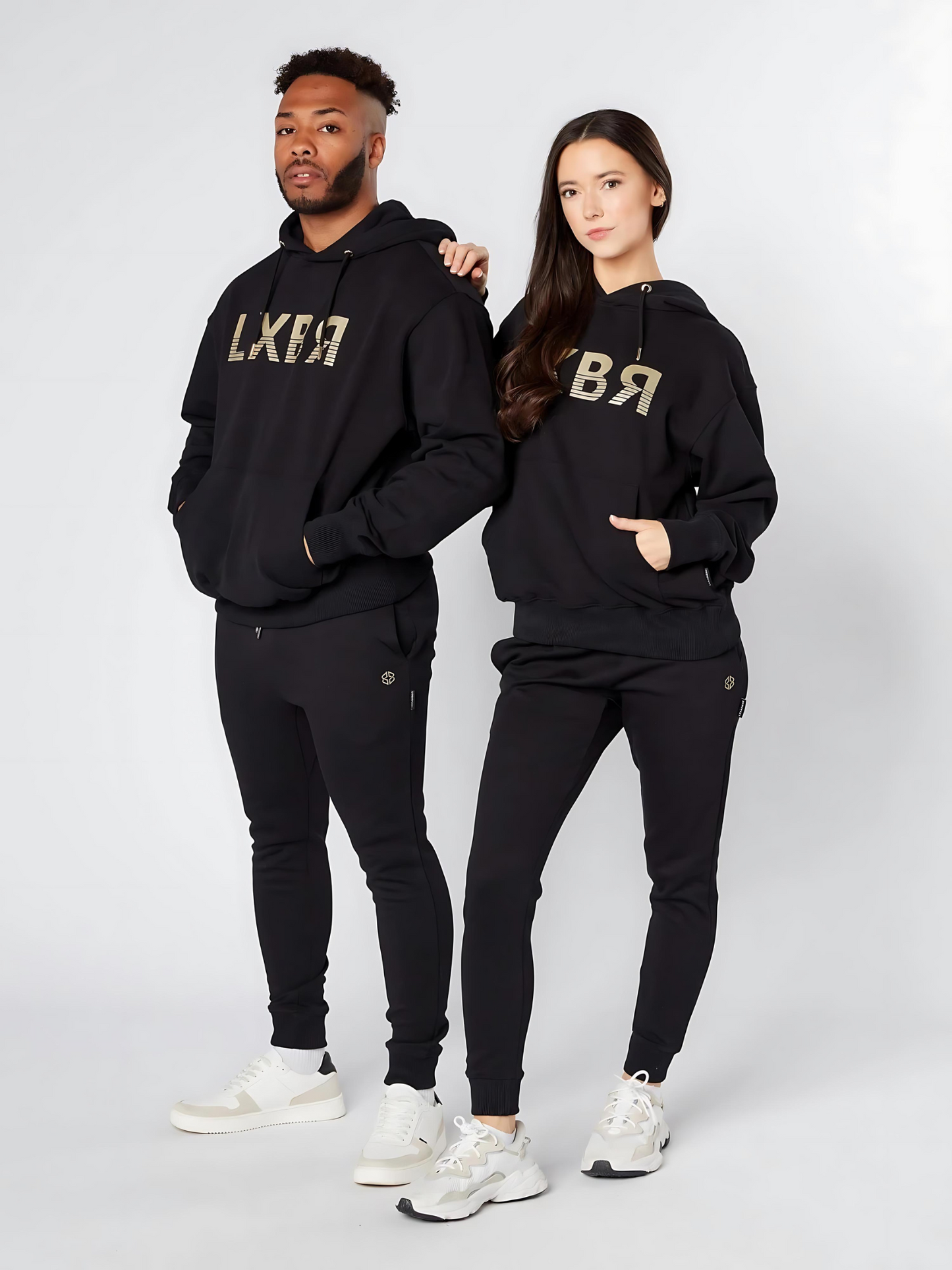 Models wearing black unisex oversized hoodies with golden 'LXBR' print on chest - Lexanber UK