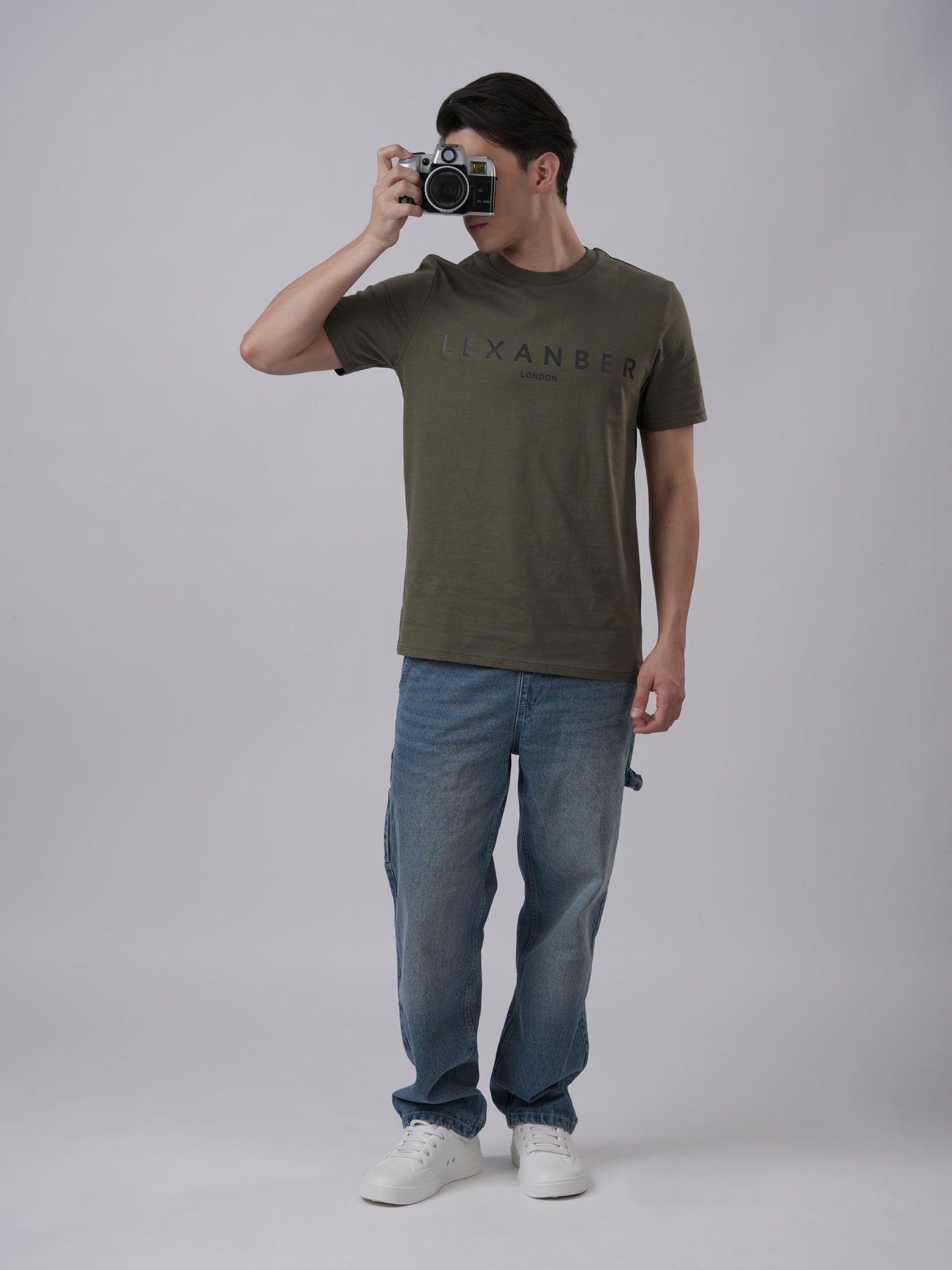 Person wearing a olive green t-shirt with 'LEXANBER' branding - front view3